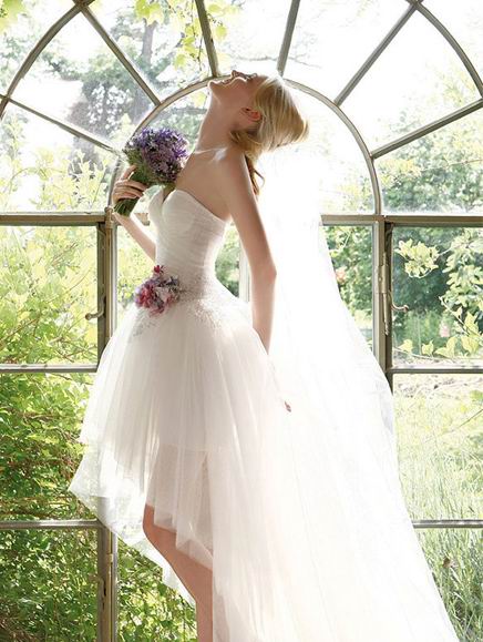 belle photo de mariée portant la robe de mariage courte et un bouquet de lavandes